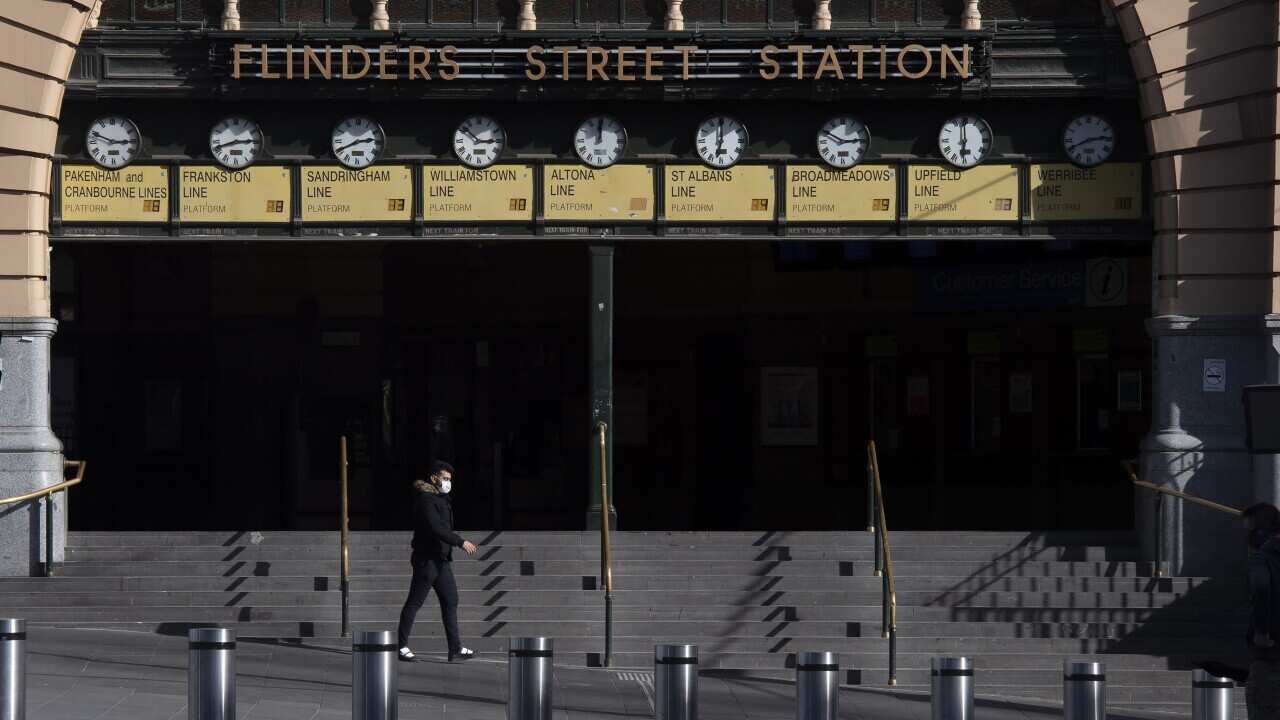 A man is seen walking out the front of Melbourne's Flinders Street Station.