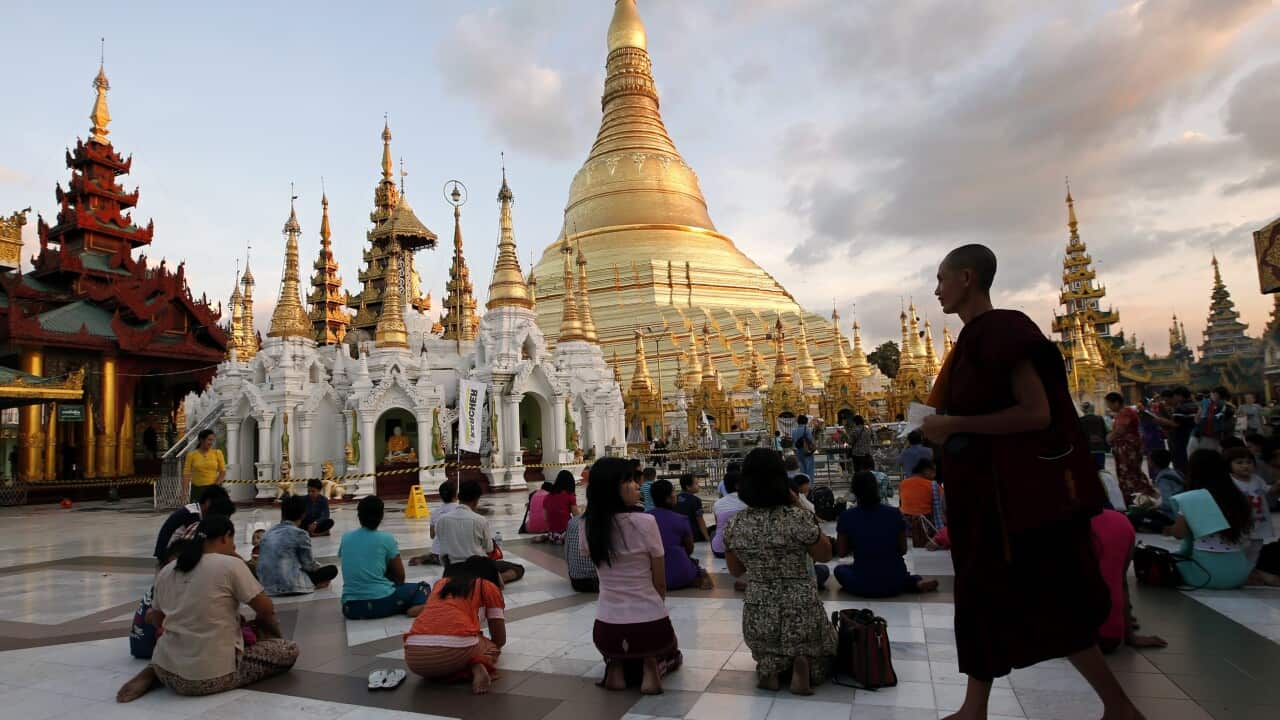 A Myanmar Buddhist monk walks next to worshippers at Shwedagon Pagoda in Yangon, Myanmar, 06 November 2015. Known also as the 'Great Dagon Pagoda', or 'Golden Pagoda' the gilded stupa is one of the landmark buildings of Yangon. (EPA)