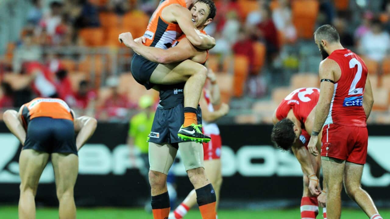 Former Sydney Swan Shane Mumford celebrates with Giants' teammates.