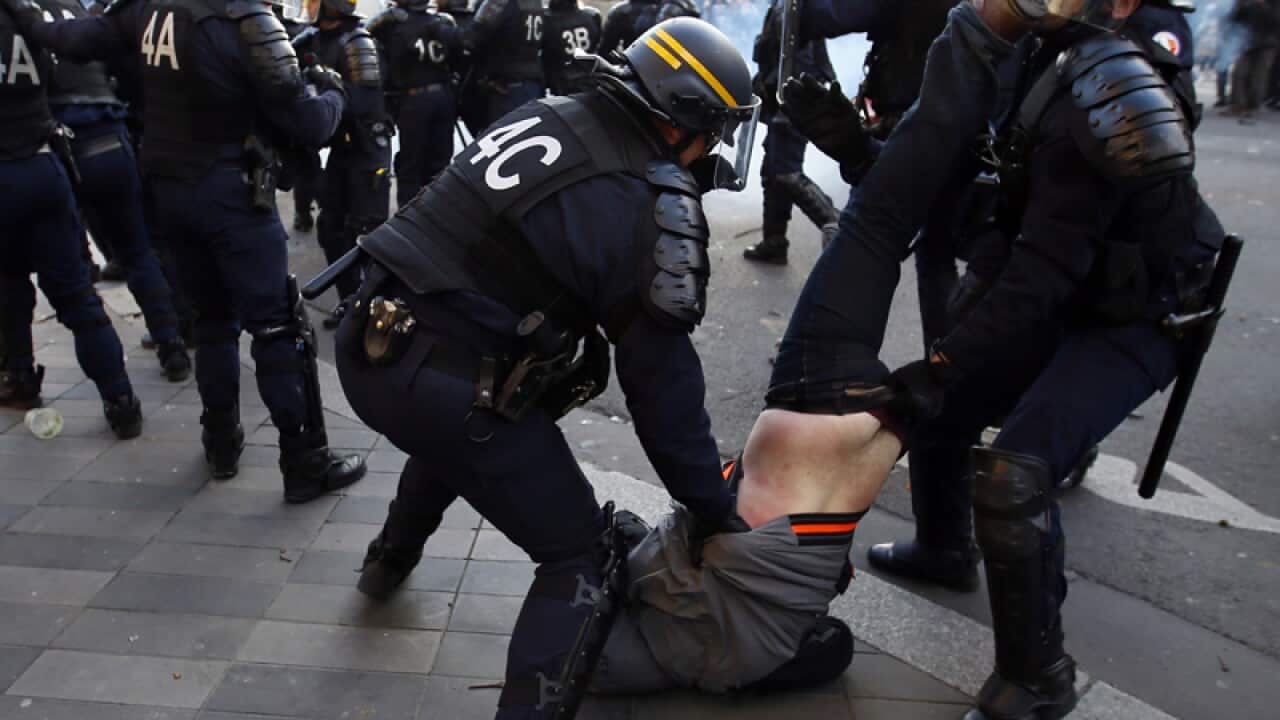 Riot Police officers apprehend a protester during clashes