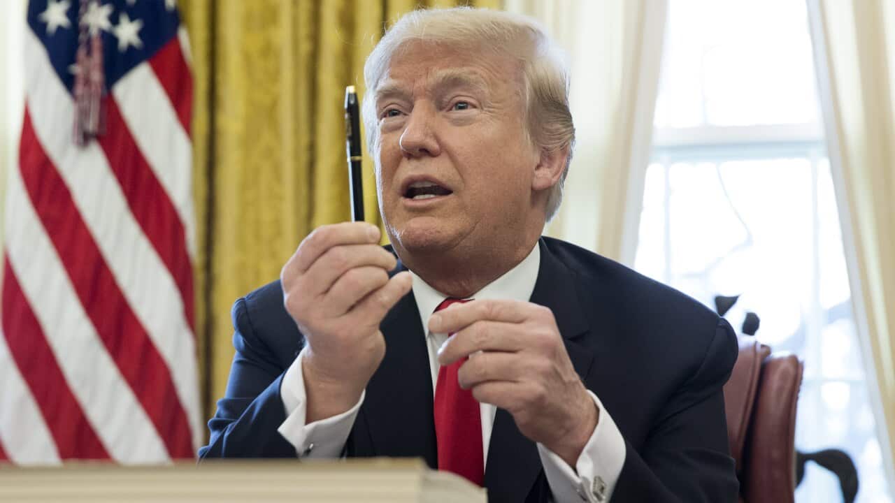 US president Donald Trump holds a pen