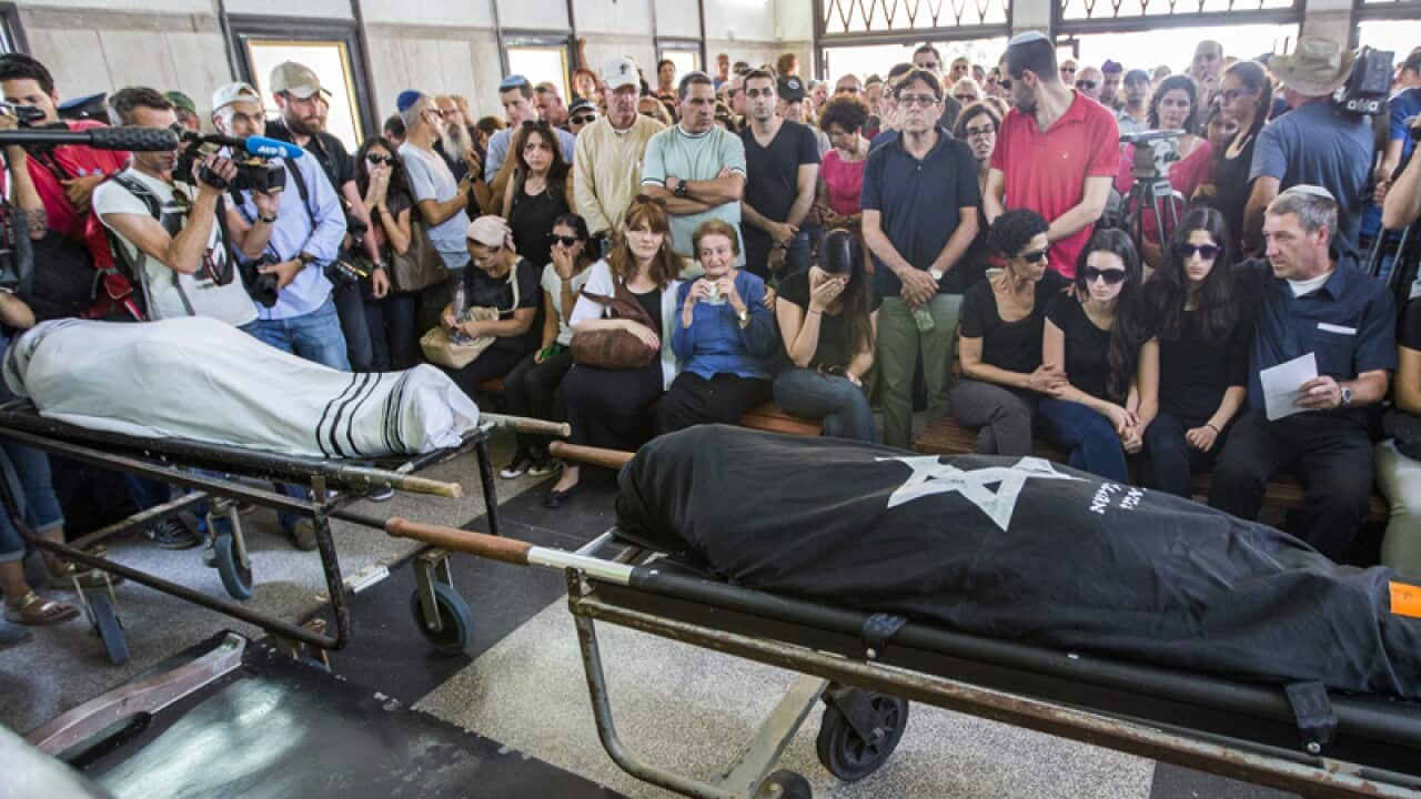 Relatives mourn over the bodies of two Israelis killed in Brussels