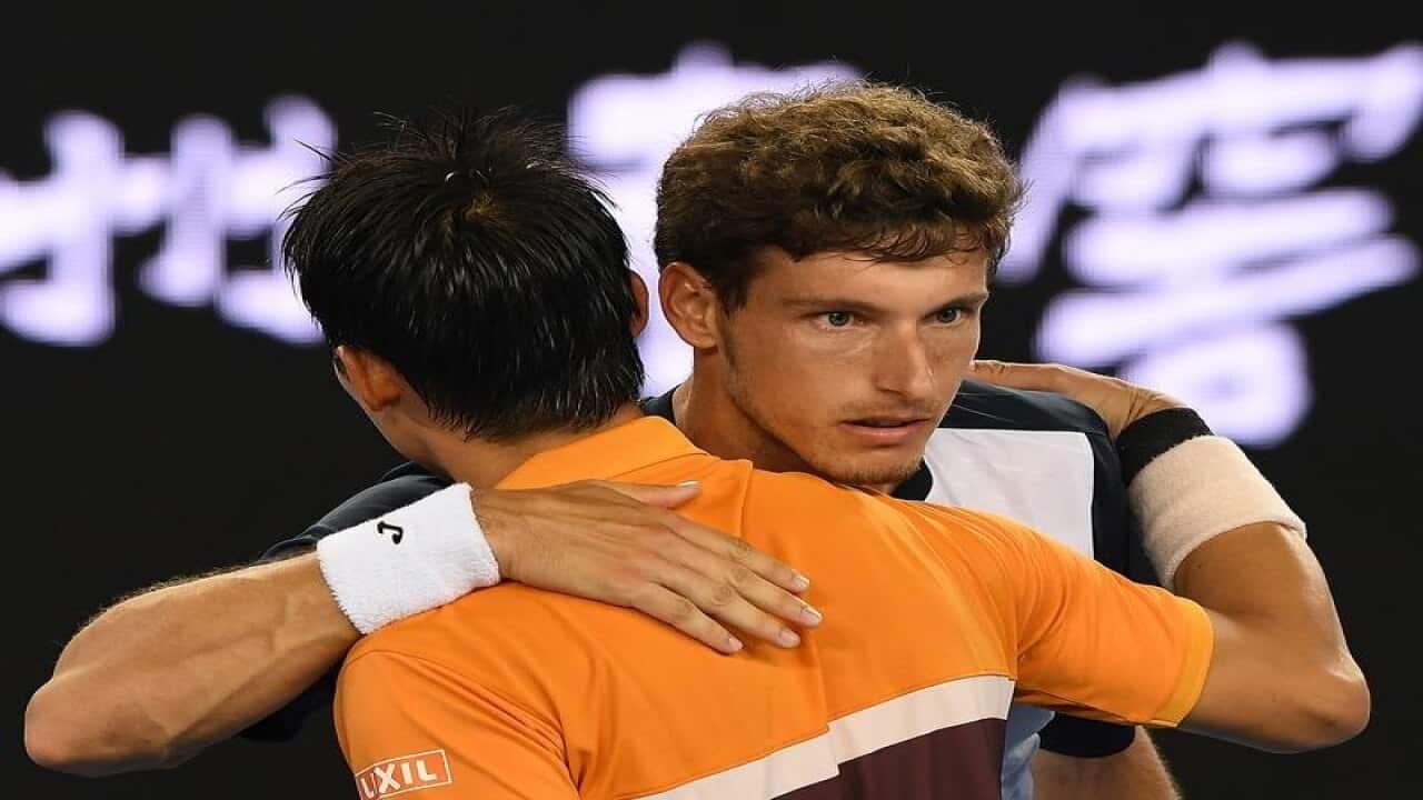 Kei Nishikori beats Pablo Carreno Busta (r).