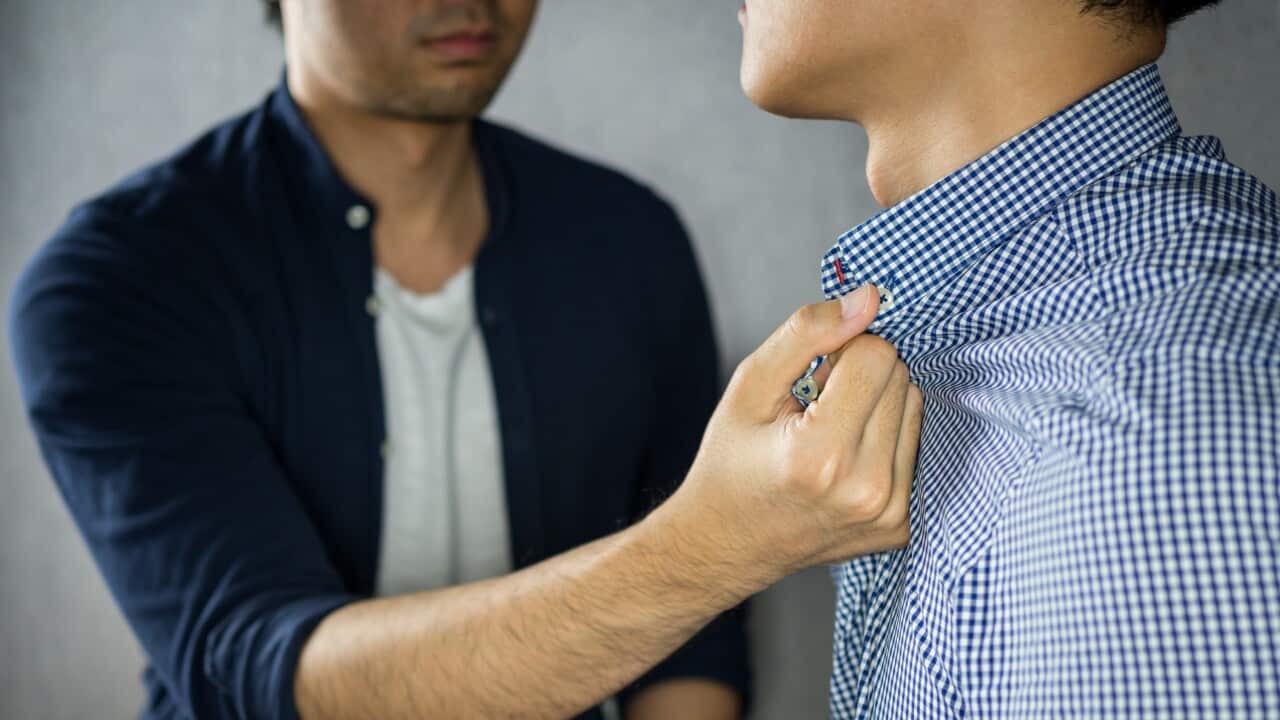 Man grab other by the collar, having argument