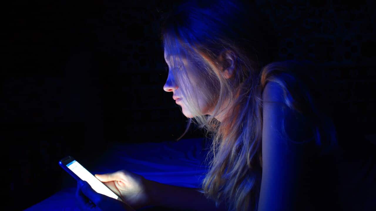 young woman using the smart phone on bed before sleep