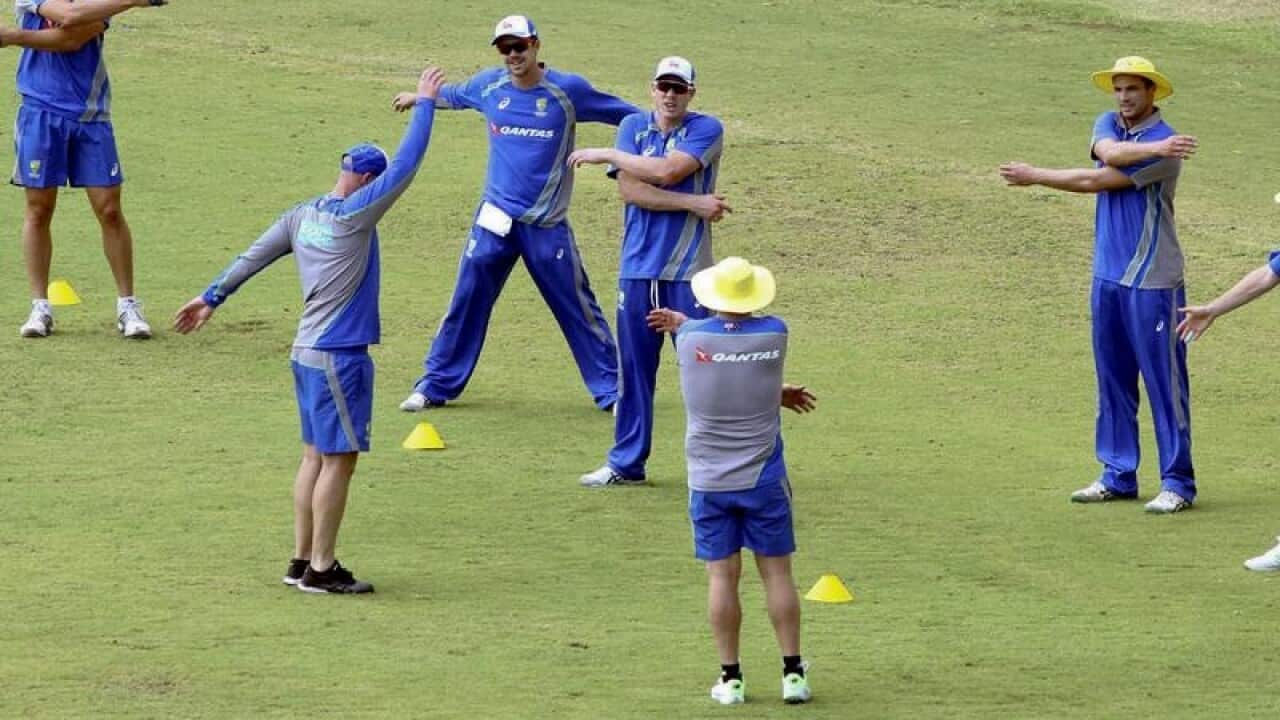 Australian cricket team members warm up during a practice session.