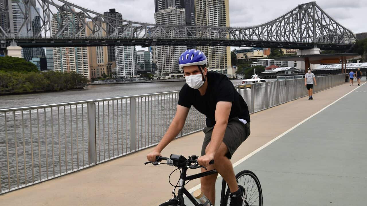 A cyclist is seen riding along the New Farm Riverwalk in Brisbane.