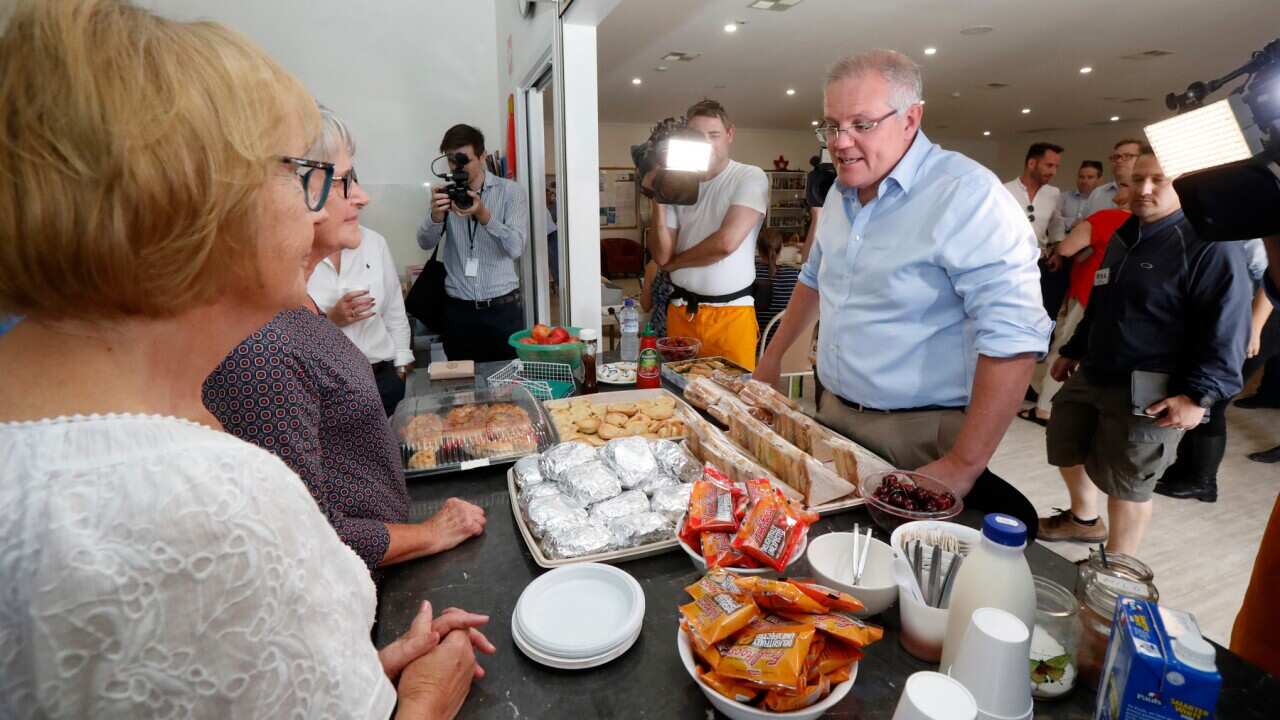 Prime Minister Scott Morrison speaks with volunteers while visiting the relief centre in Lobethal, South Australia, Tuesday, December 24, 2019. The Prime Minister is touring fire affected areas in South Australia. (AAP Image/Kelly Barnes) NO ARCHIVING