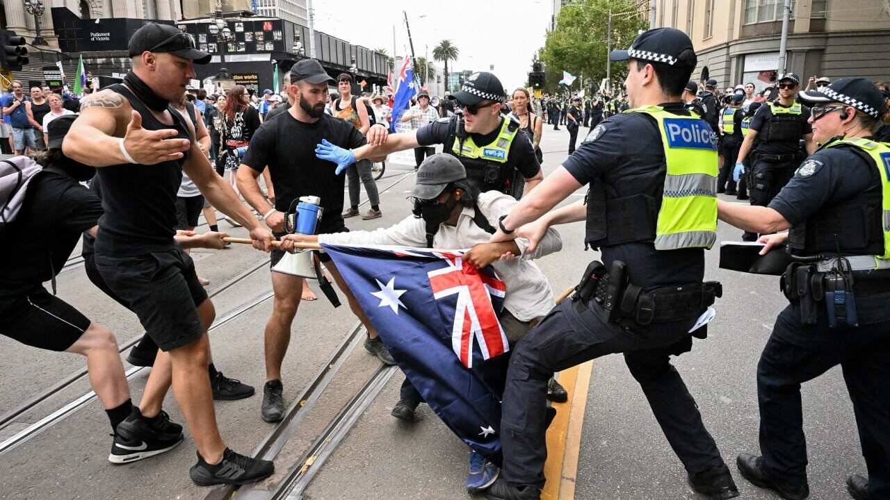 Police clash with a protester on the streets of Melbourne.