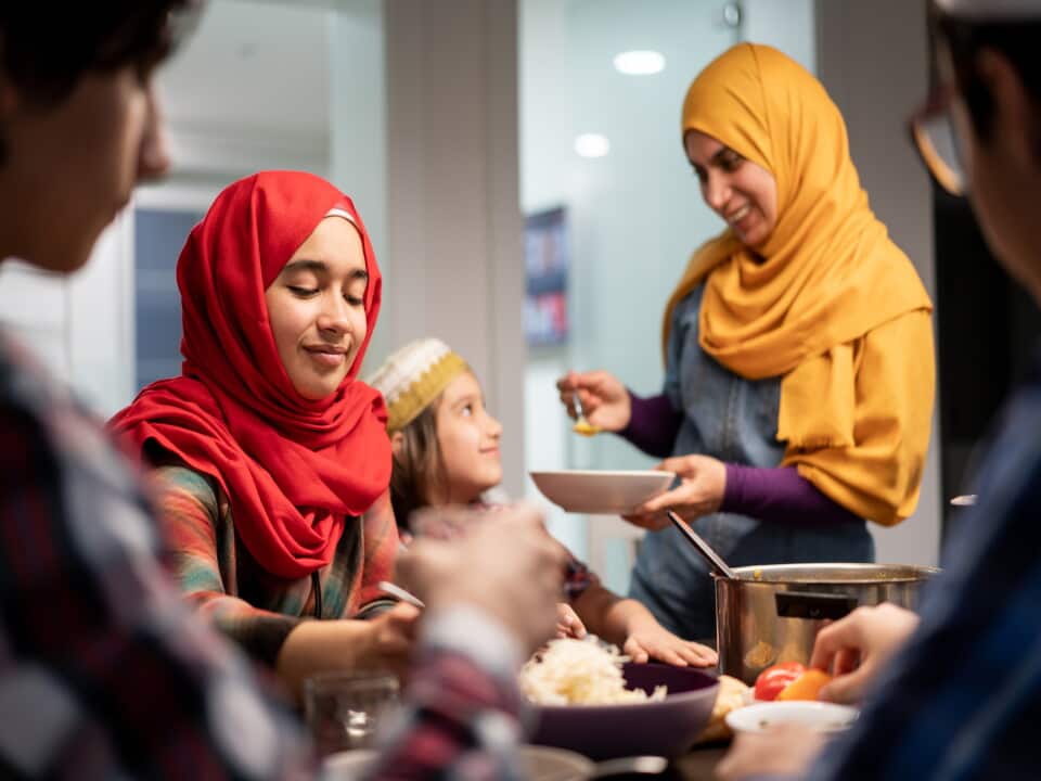 Muslim family eating Iftar and enjoying breaking of fasting.