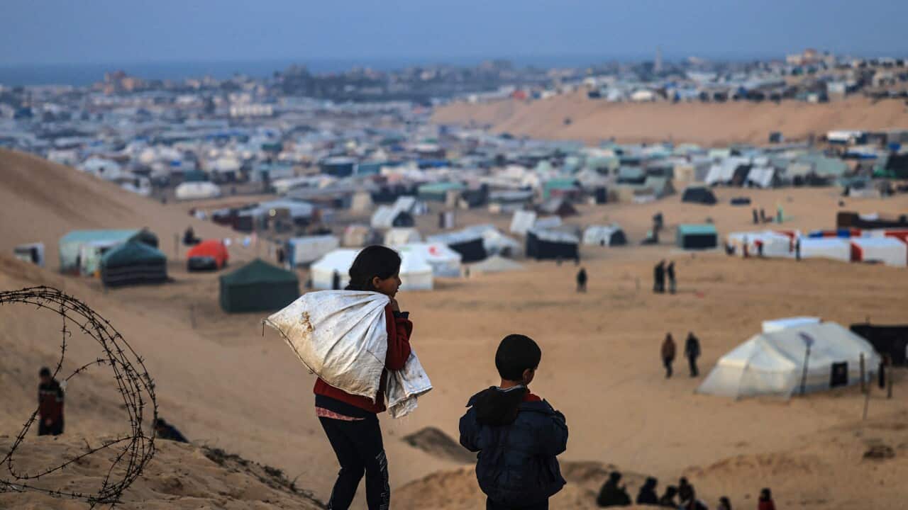 Two small children looking over on makeshift homes of displaced people.