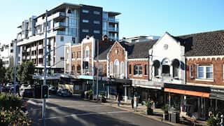 Shops and apartment buildings are seen adjacent to a railway station