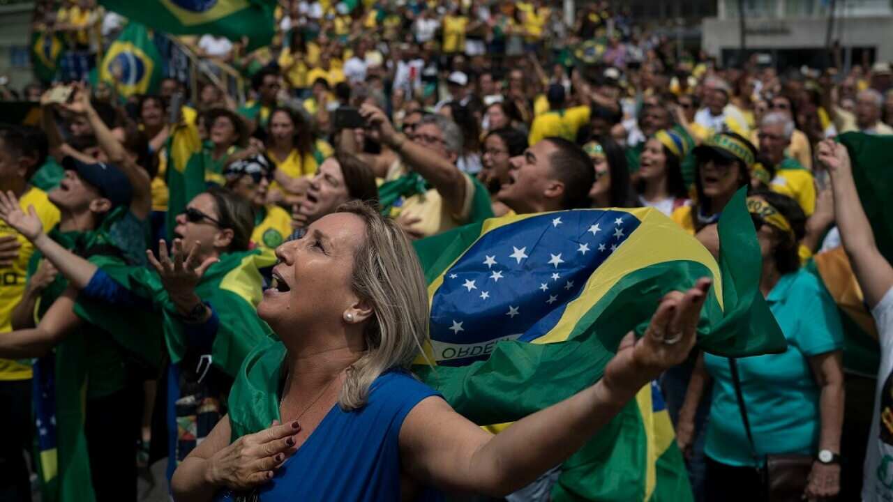 Supporters of Jair Bolsonaro sing Brazil's national anthem during a campaign rally.