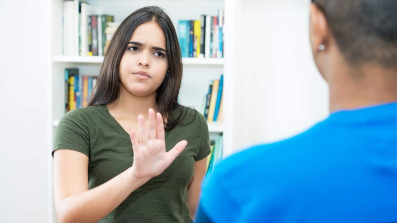 Hispanic female young adult gesturing stop and social distancing