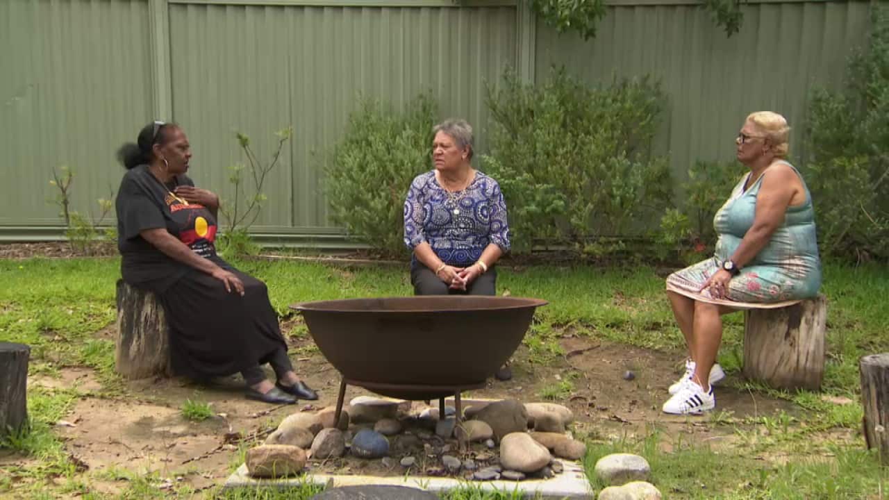 Auntys at the Baabayn Aboriginal Corporation sit around a fire place talking.