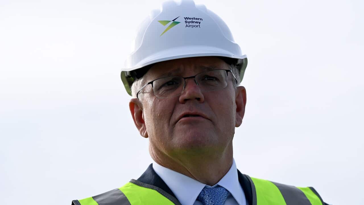 Prime Minister Scott Morrison wears a safety vest and hard hard during a visit to the Western Sydney Airport site.
