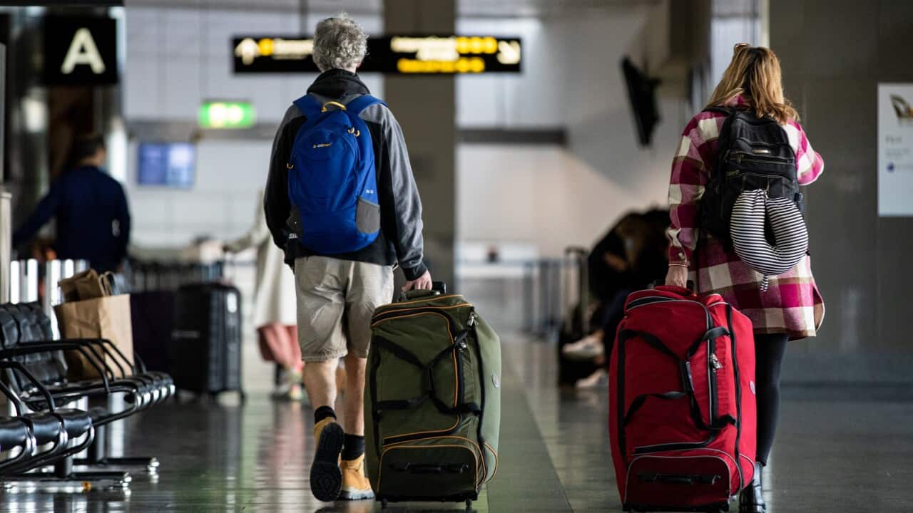 People pulling suitcases in an airport