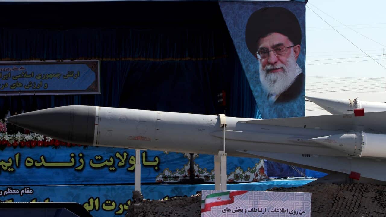 In front of a picture of Iranian supreme leader Ayatollah Ali Khamenei a military trucks carrying an Iranian mid-range missile in a military parade