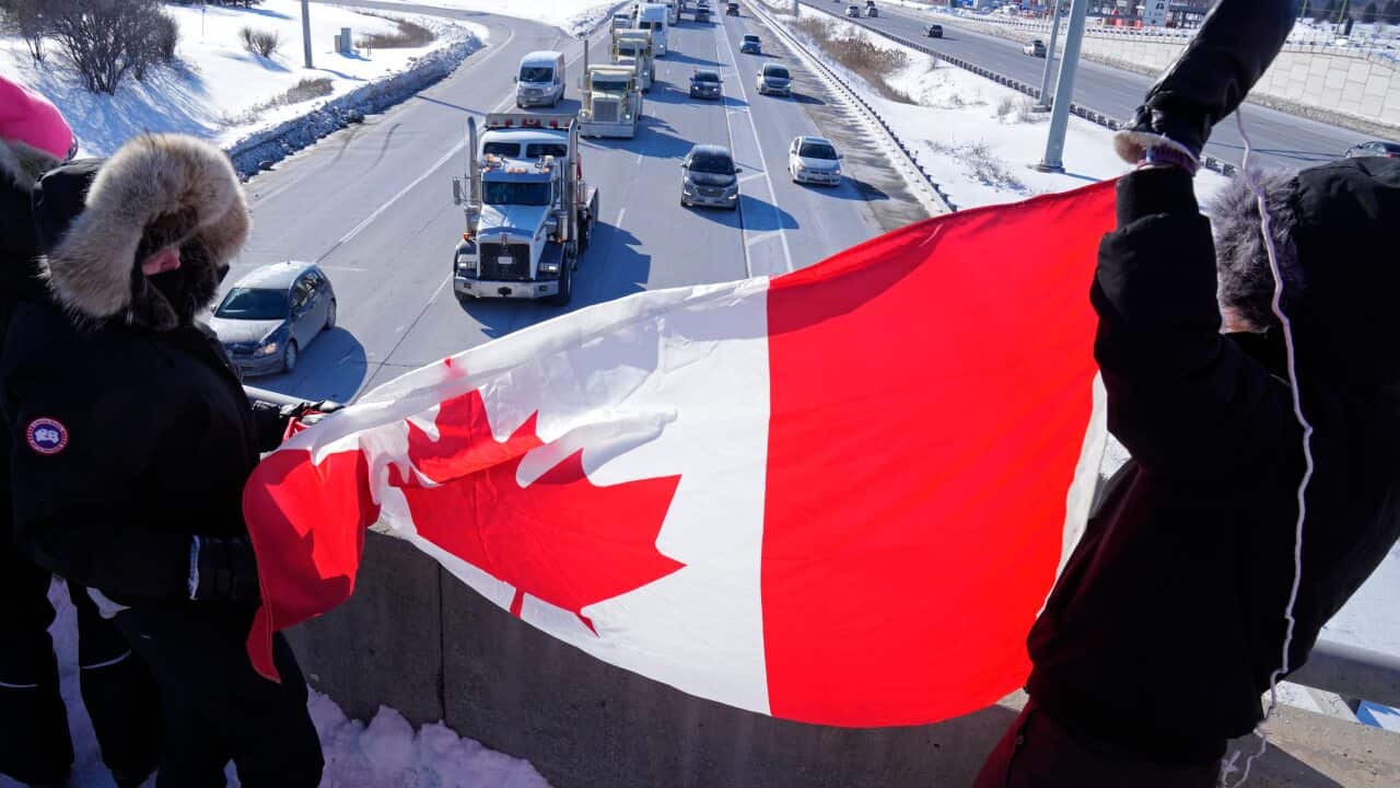 Supporters wave Canadian flags on an overpass