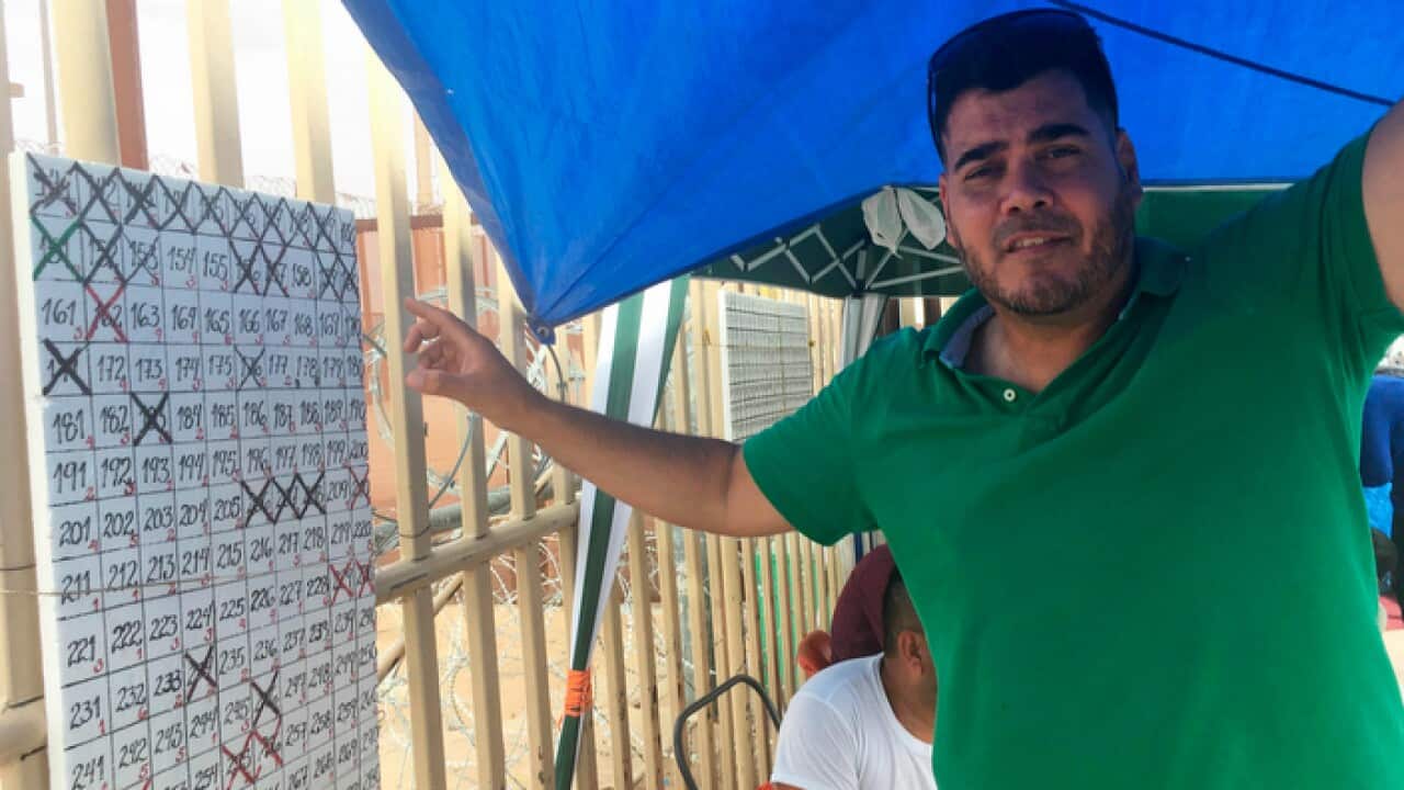 Darwin Mora, an asylum seeker from Venezuela, manages a list of people waiting to claim asylum in the US