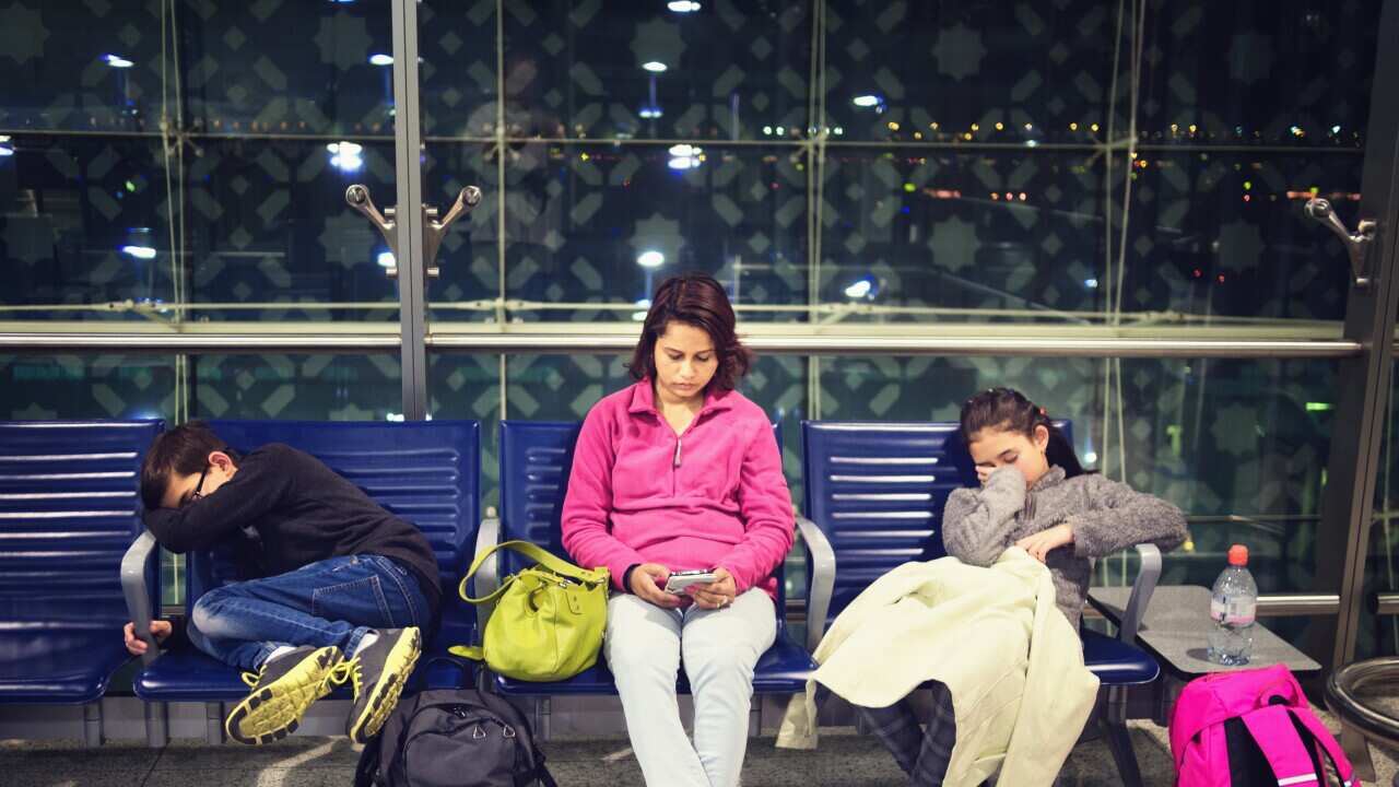 Mother and children relaxing in airport waiting area