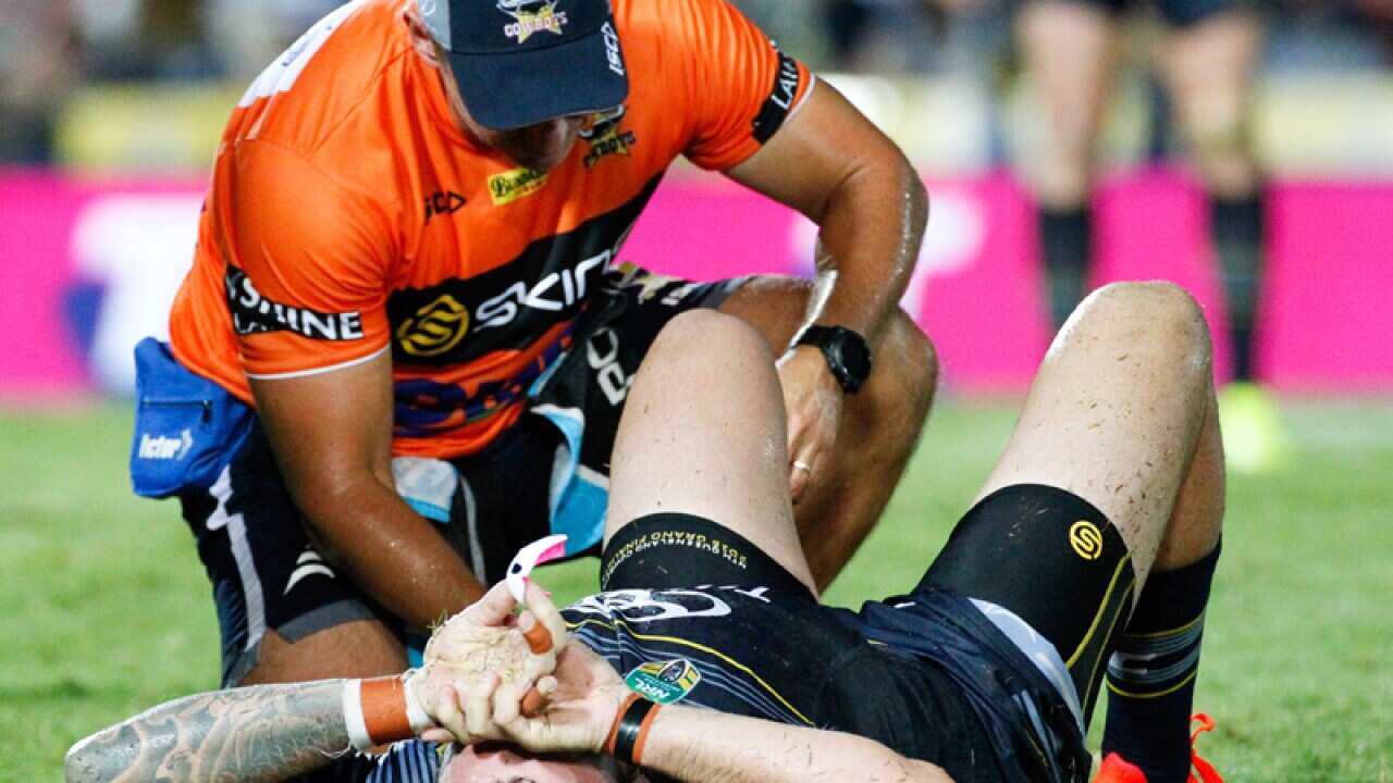 Cowboys Kyle Feldt is attended to by head trainer Steve Sartori