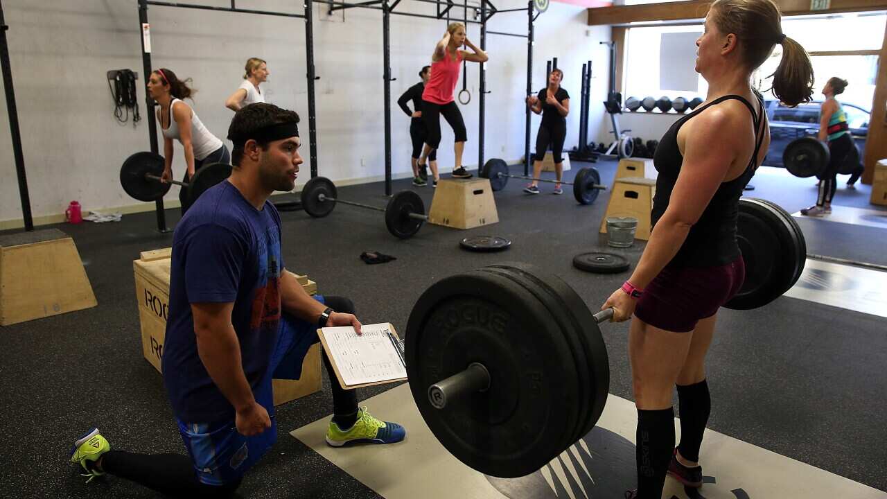 CrossFit coach Kory Cook watches Erin Lindheim do a deadlift during a CrossFit workout at Ross Valley CrossFit in California (Getty)