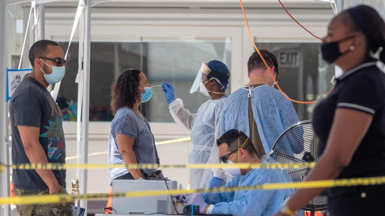 A woman receives the COVID-19 coronavirus walk-up testing service by the Florida Army National Guard