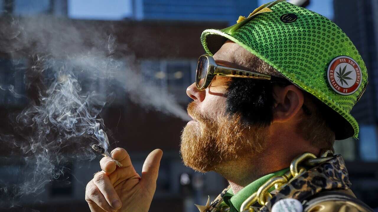 Cannabis user Scott Wells smokes a joint at a rally outside governments offices following the legalisation of cannabis in Calgary.