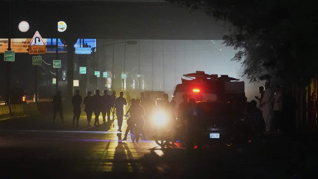 Police officers moving people along at an airbase.