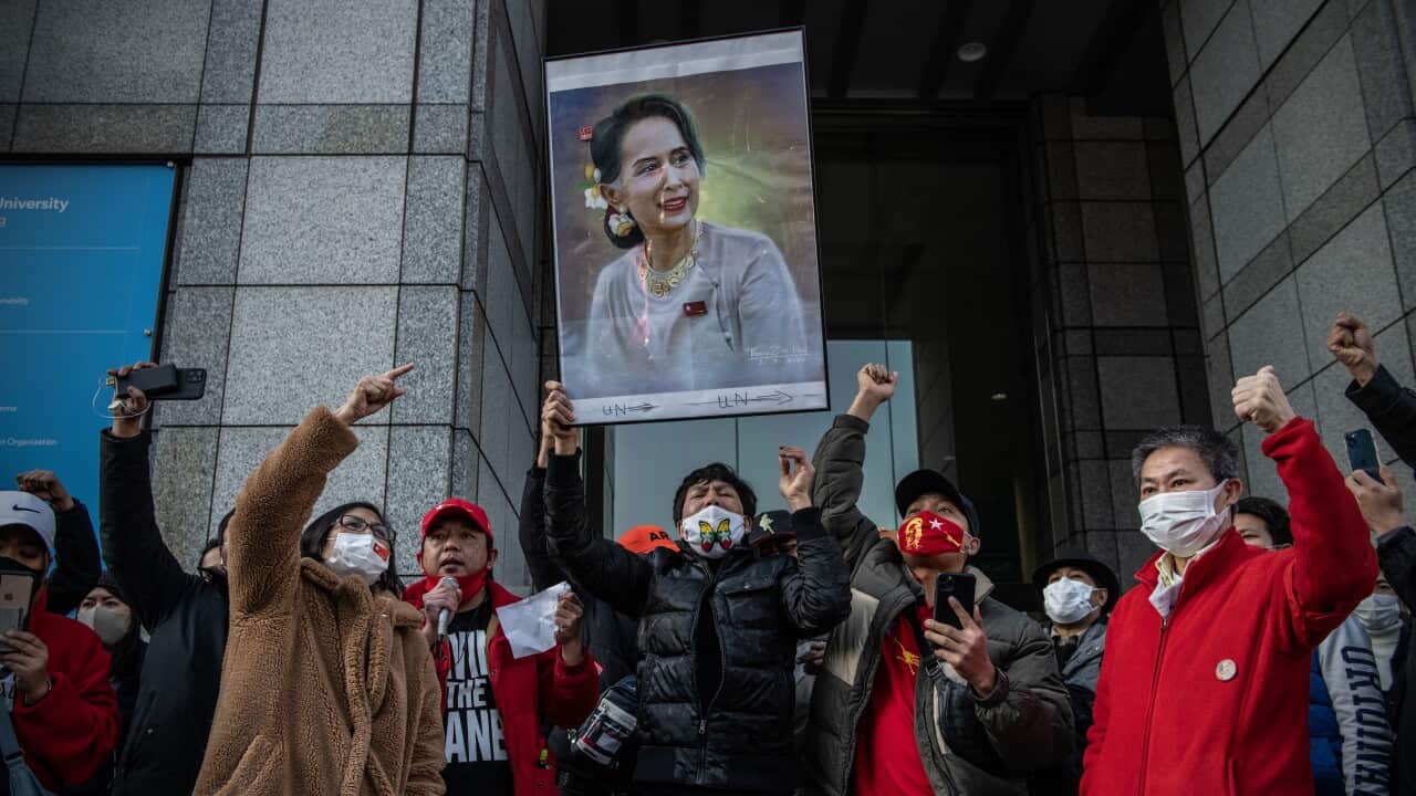 A poster of Aung San Suu Kyi is held aloft as Myanmarese people in Tokyo demonstrate against the coup that took place in their home country on 1 February.