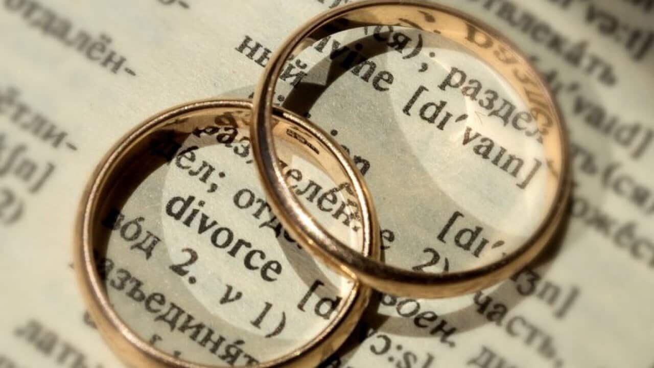 Two separate wedding rings next to the word "divorce". The concept of divorce, parting, infidelity . Selective focus.