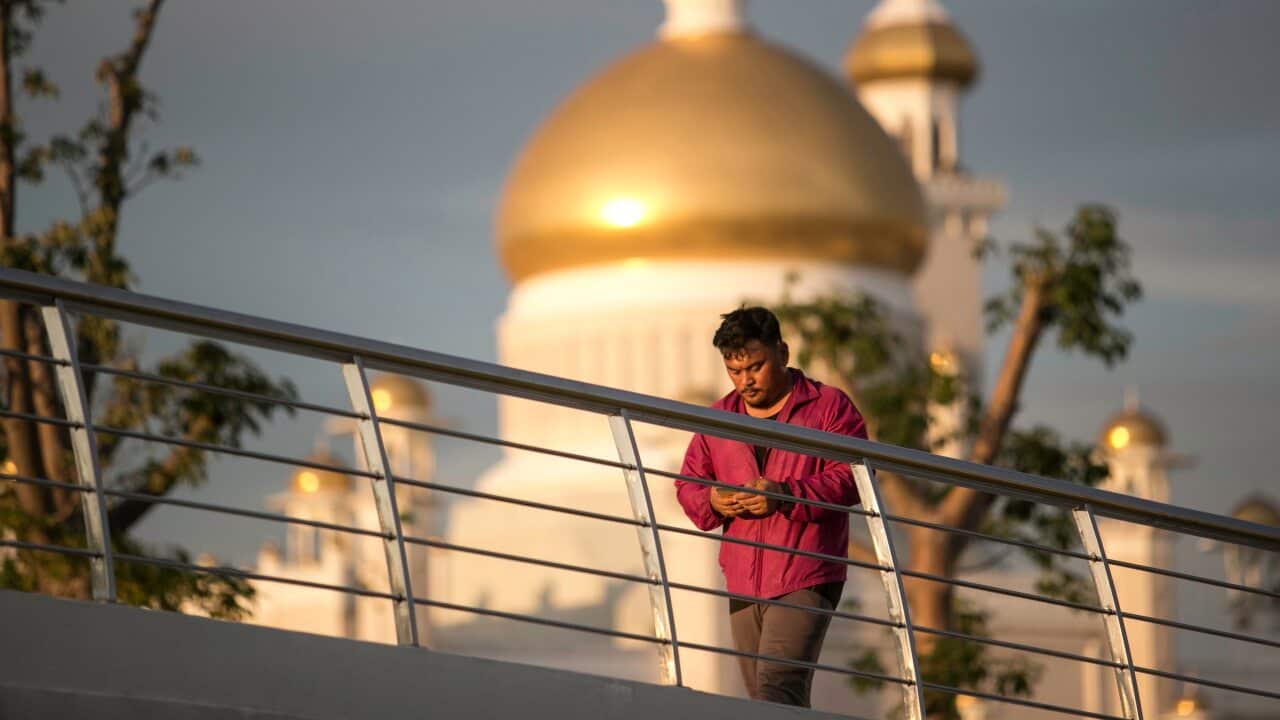 A man walks past the Sultan Omar Ali Saifuddien mosque while doing his afternoon exercise at Taman Mahkota Jubli Emas park, in Bandar Seri Begawan, Brunei.