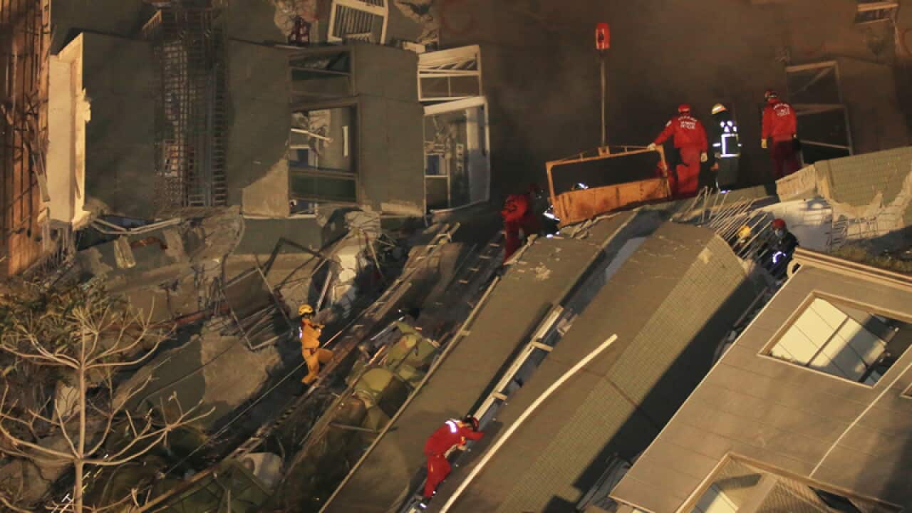 Rescue workers search a collapsed building