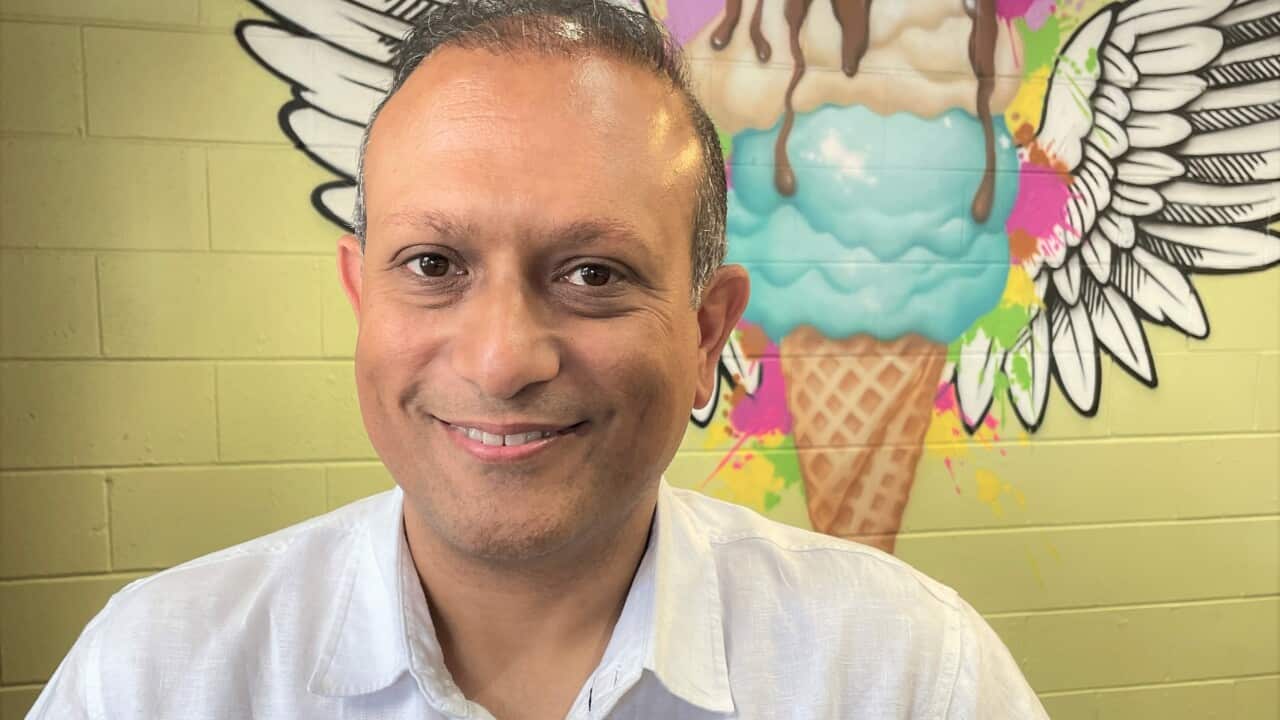 Kaveh Arfai sitting in front of a mural at a C9 outlet in Sydney.