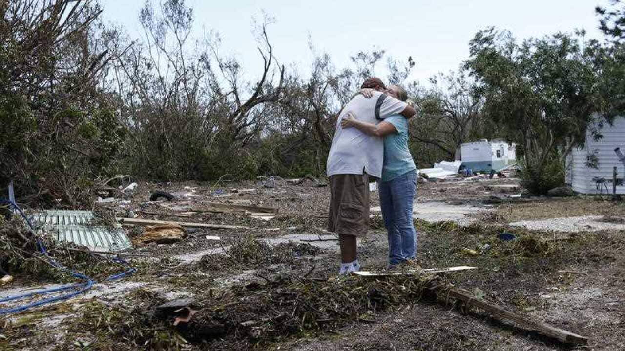 Amy Seiler, left, manager of the Driftwood Trailer Park, hugs resident Sergio Gregorio after surveying the damage at the trailer park, Tuesday, Sept. 12, 2017,