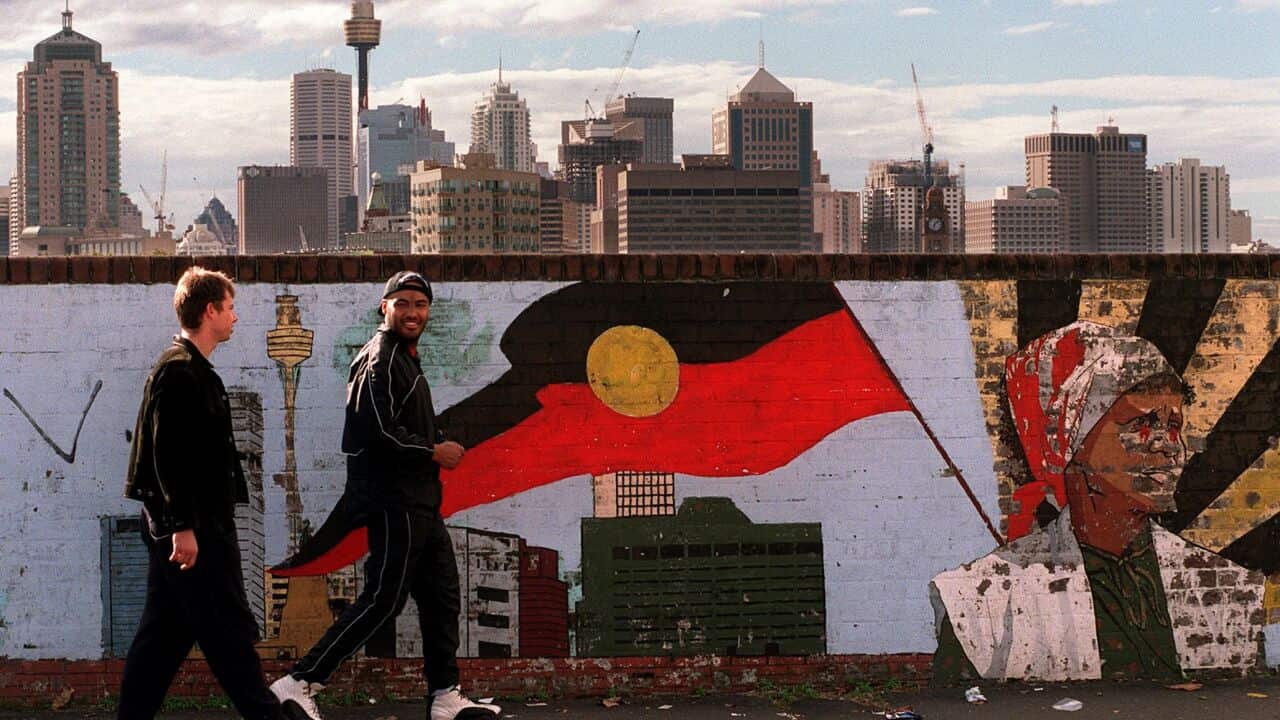A Koori youth (R) walks with his white f