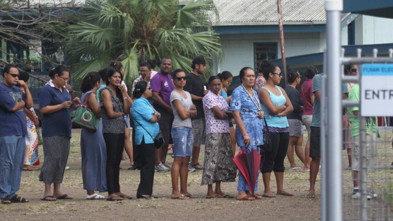 Fijian voters wait in line at a polling station