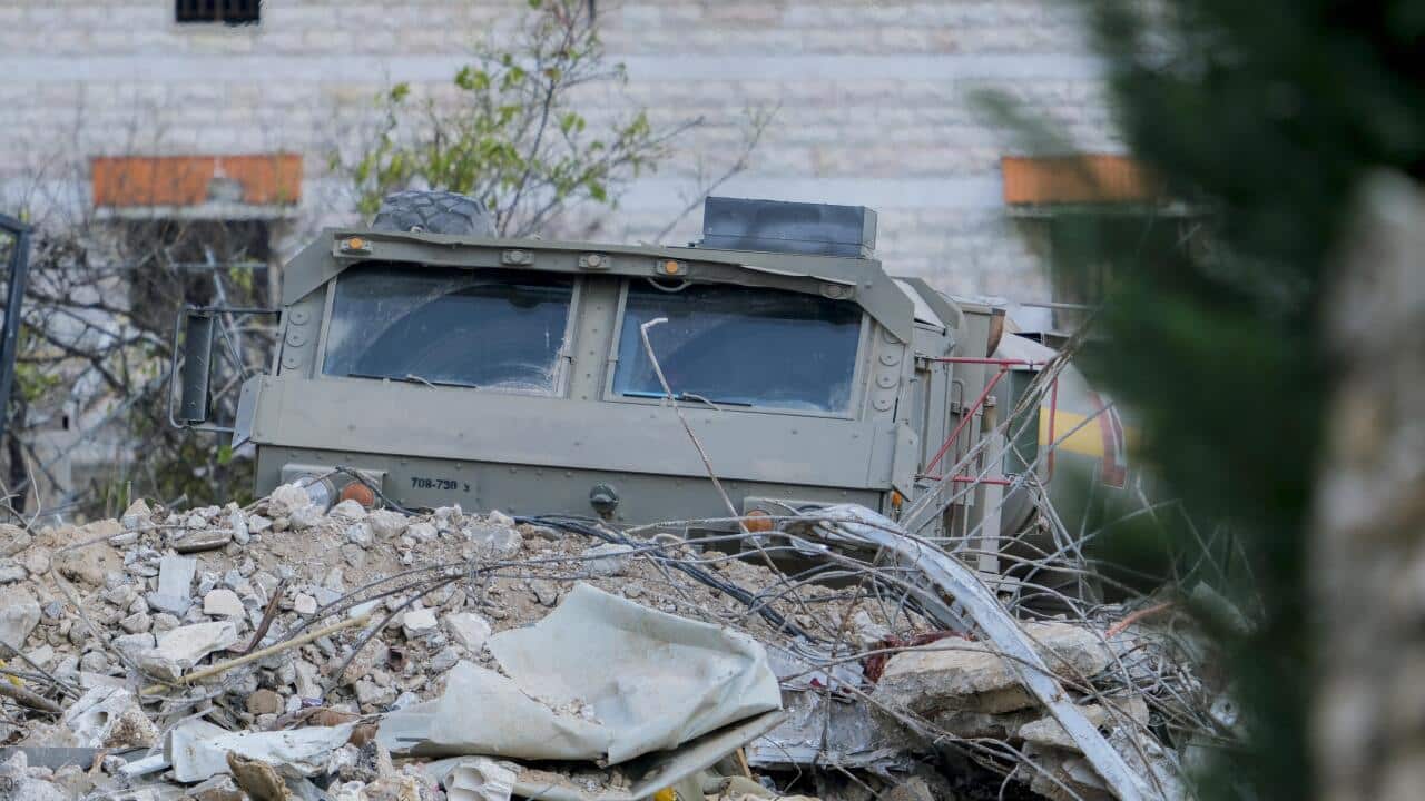 Israeli Soldiers Gather Behind Rubble In A Southern Lebanese Village