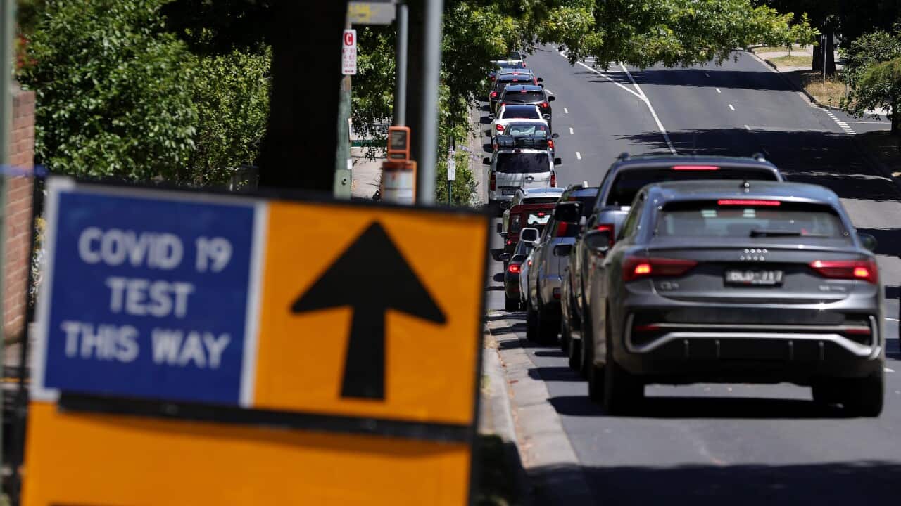 Members of the public are seen queuing in their cars on Elgar Road at a drive-through COVID-19 testing site.