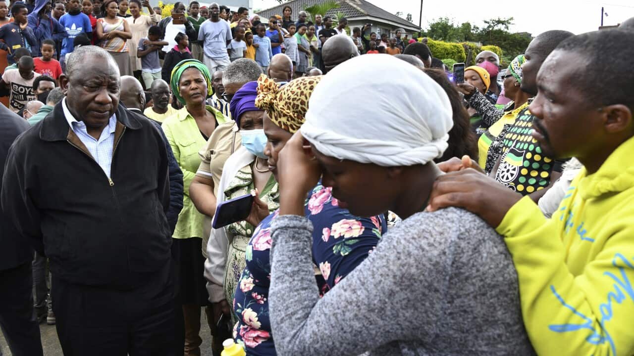 South African President Cyril Ramaphosa (left) speaks to grieving family members in the aftermath of heavy rainfall and floods near Durban.