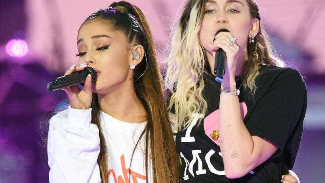 Ariana Grande, left, and Miley Cyrus perform at the One Love Manchester tribute concert in Manchester, north western England, Sunday, June 4, 2017.