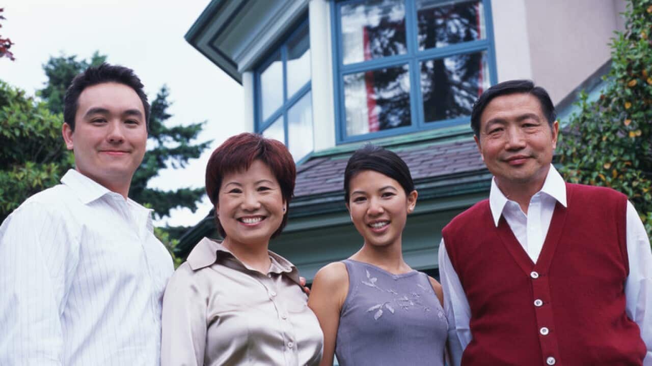 Couple standing outside house