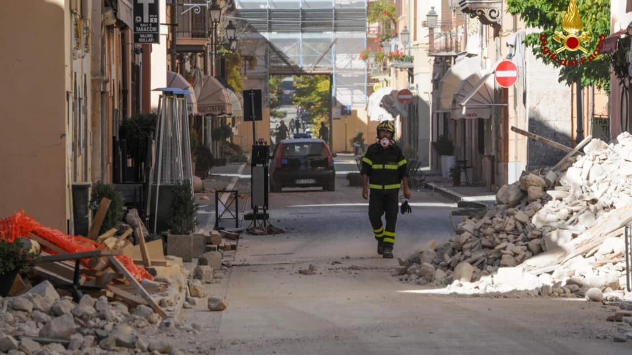 A firefighter walking through rubble in Norcia, in the Umbria region, Italy.