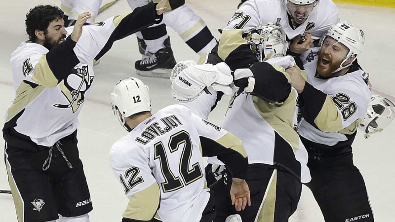 Pittsburgh Penguins players celebrate around goalie Matt Murray