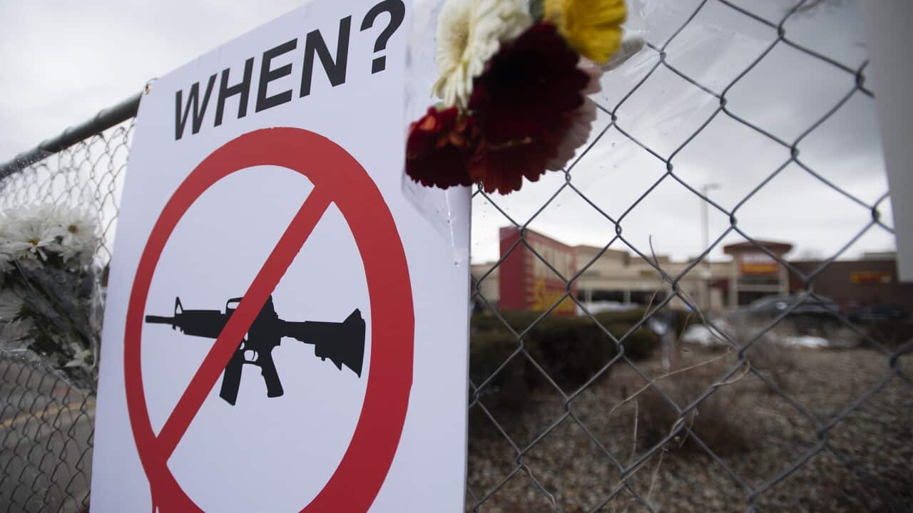 A sign hangs on a fence at a memorial outside King Soopers for the victims of the recent mass shooting in Boulder, on Tuesday, March 23, 2021.