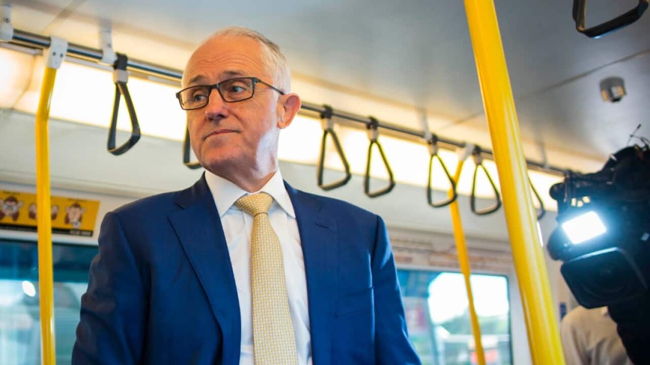 Prime Minister Malcolm Turnbull rides a train with Western Australian Premier Mark McGowan in Perth on April 28