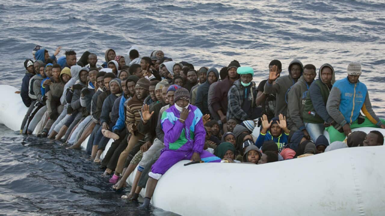 Migrants and refugees wait to be helped, north of Sabratha, Libya