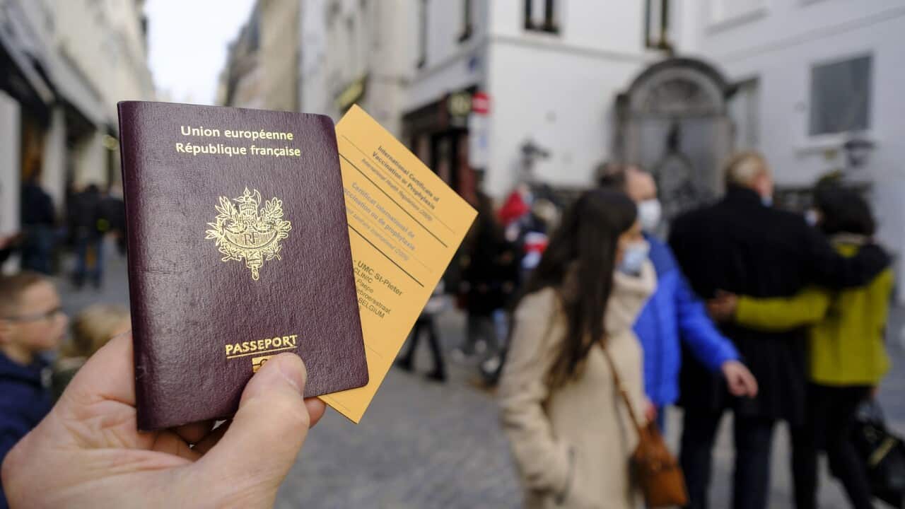 A French passeport and an International Certificate of Vaccination or Prophylaxis are seen in an illstration pictures on February 19, 2021 in Brussels, Belgium. Back is the famous statue of the Manneken-Pis. - Photo by Monasse T/ANDBZ/ABACAPRESS.COM.