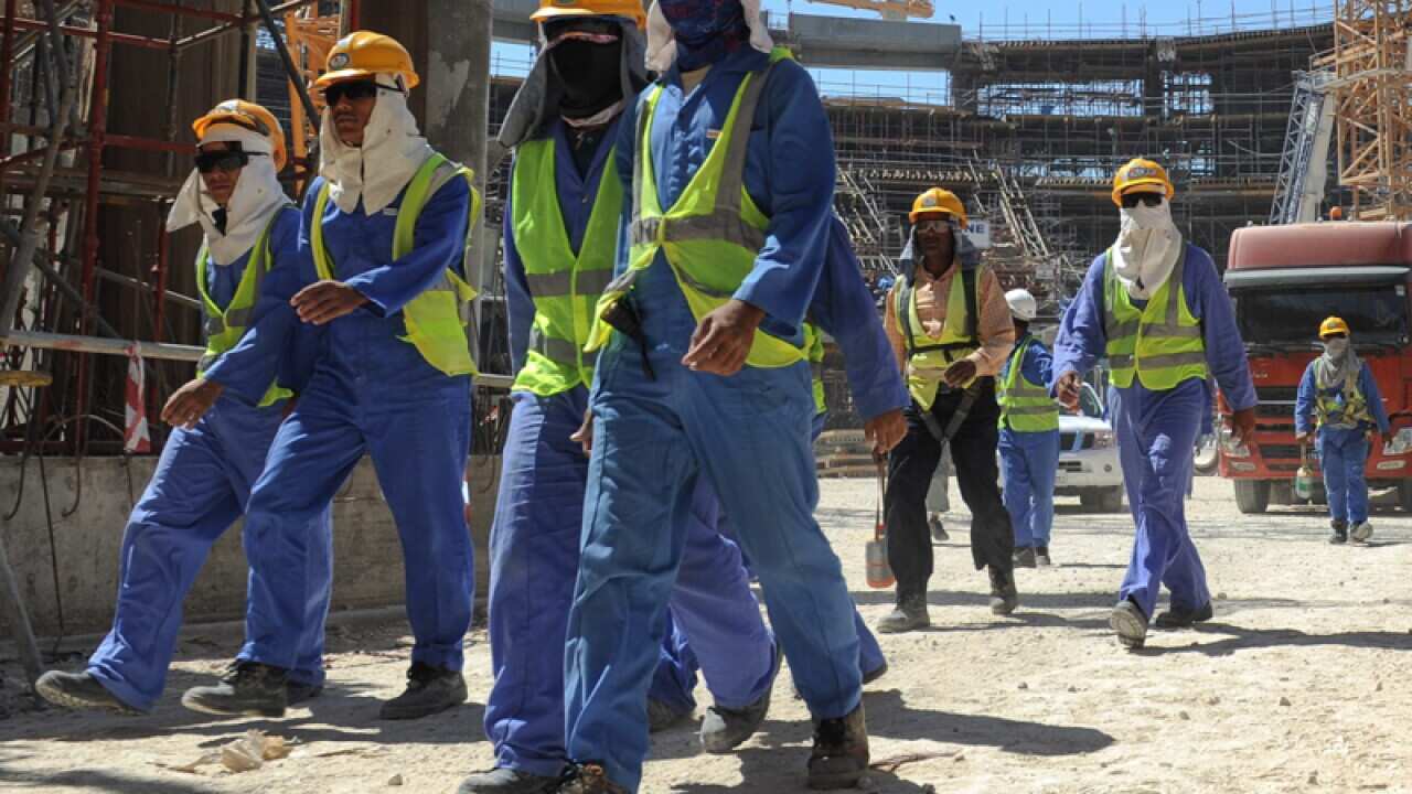 Foreign construction workers leave a construction site in Qatar